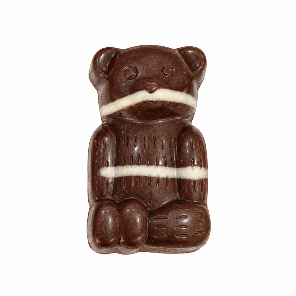 Praline artisanale en forme d’ourson en chocolat noir, décorée de fines lignes claires, garnie d’un praliné noisette au sucre pétillant.